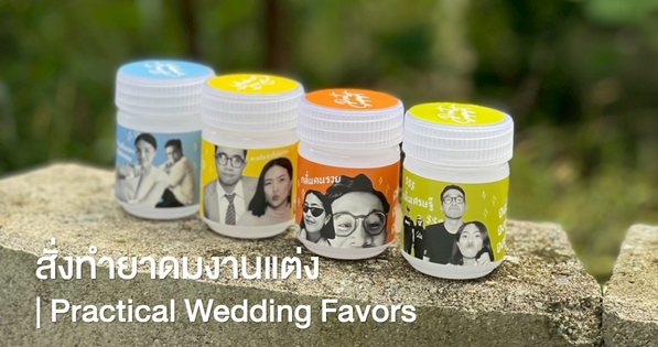 Custom herbal inhaler wedding favors with personalized couple labels arranged beside invitations and flowers.
